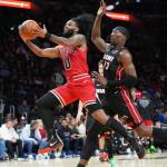 Chicago Bulls guard Coby White (0) drives to the basket as Miami Heat center Bam Adebayo (13) defends during the second half of an NBA basketball game, Sunday, Feb. 1, 2026, in Miami. (AP Photo/Lynne Sladky)