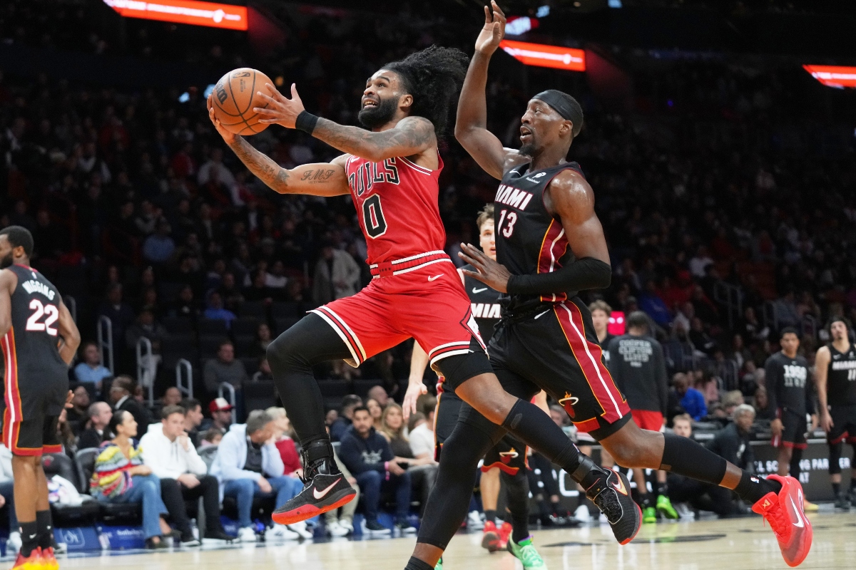 Chicago Bulls guard Coby White (0) drives to the basket as Miami Heat center Bam Adebayo (13) defends during the second half of an NBA basketball game, Sunday, Feb. 1, 2026, in Miami. (AP Photo/Lynne Sladky)
