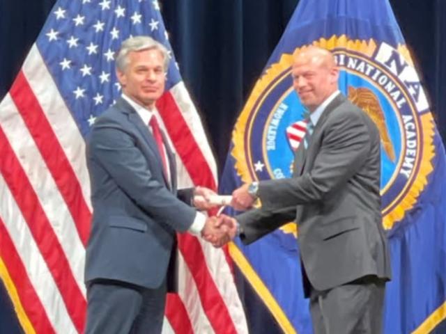 On June 9, 2023, the city posted a photo of Mark Pingsterhaus shaking hands with then FBI Director Christopher Wray, heralding Pingsterhaus completing the FBI Academy. Pingsterhaus later was suspended amidst an FBI investigation. (City of Carlyle Facebook page.)