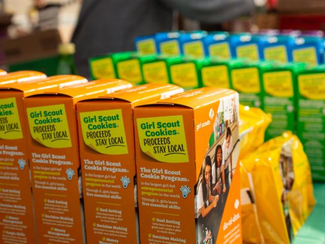 : A closeup view of several varieties of Girl Scout Cookies on display on a table.