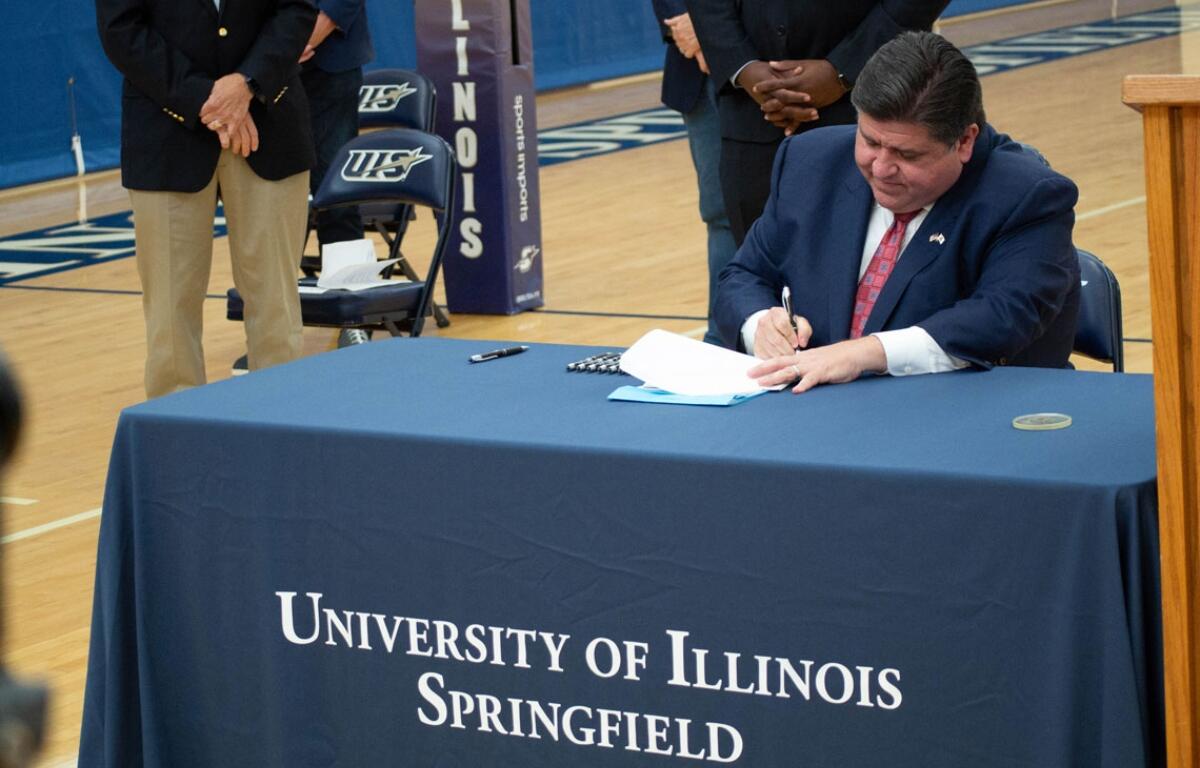 Gov. JB Pritzker signs legislation at the University of Illinois Springfield in 2021. (Capitol News Illinois photo by Jerry Nowicki)
