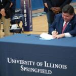 Gov. JB Pritzker signs legislation at the University of Illinois Springfield in 2021. (Capitol News Illinois photo by Jerry Nowicki)