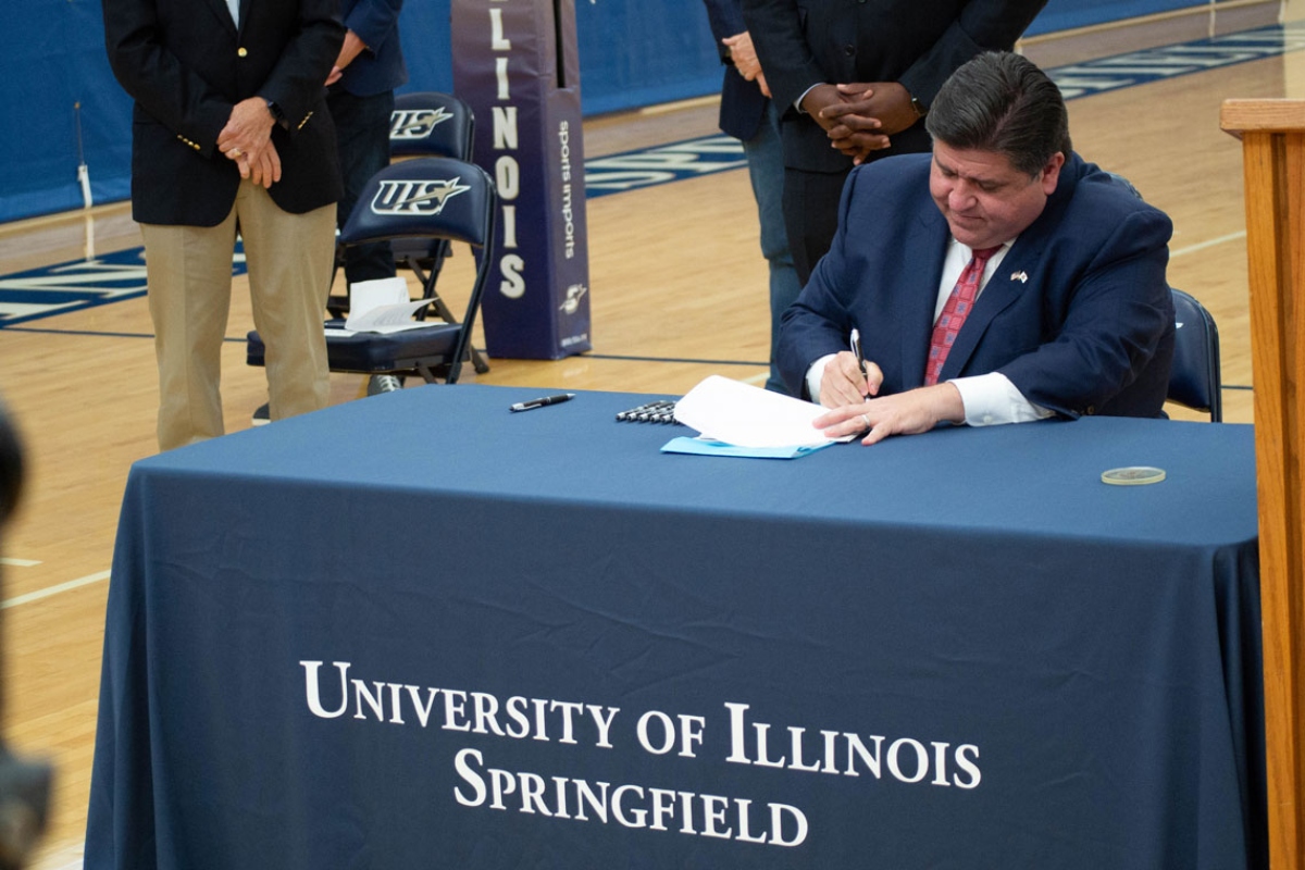 Gov. JB Pritzker signs legislation at the University of Illinois Springfield in 2021. (Capitol News Illinois photo by Jerry Nowicki)