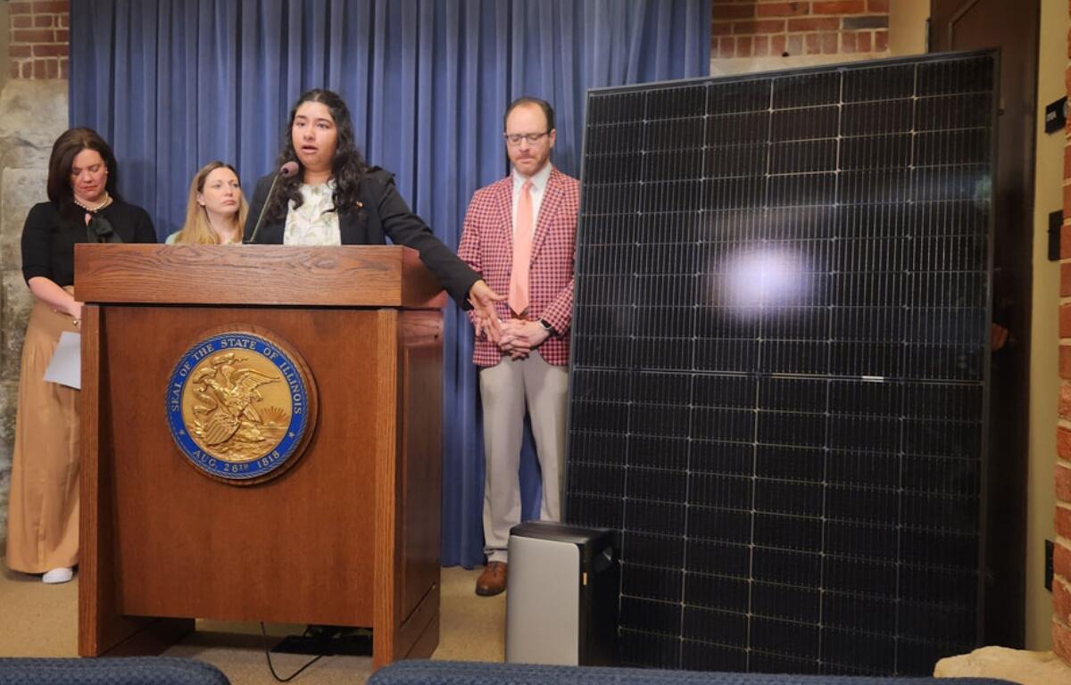 Kavi Chintham of Voter Solar gestures at a 391-watt plug-in solar panel and battery at a Thursday news conference about a bill to expand access to plug-in solar panel systems. (Capitol News Illinois photo by Nikoel Hytrek)
