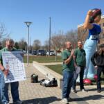 Dathan Powell (center, in green), chair of UIS United Faulty, speaks as the results of a strike authorization vote were made public Thursday, March 19.