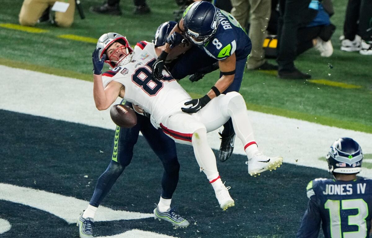 New England Patriots tight end Hunter Henry (85) is unable to catch a two-point conversion as Seattle Seahawks' Coby Bryant (8) and Josh Jobe, rear, defend during the second half of the NFL Super Bowl 60 football game, Sunday, Feb. 8, 2026, in Santa Clara, Calif. (AP Photo/Charlie Riedel)