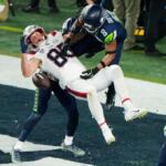 New England Patriots tight end Hunter Henry (85) is unable to catch a two-point conversion as Seattle Seahawks' Coby Bryant (8) and Josh Jobe, rear, defend during the second half of the NFL Super Bowl 60 football game, Sunday, Feb. 8, 2026, in Santa Clara, Calif. (AP Photo/Charlie Riedel)