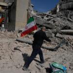 A man carries an Iranian flag to place on the rubble of a police facility struck during the U.S.–Israeli military campaign in Tehran, Iran, Wednesday, March 4, 2026. (AP Photo/Vahid Salemi)