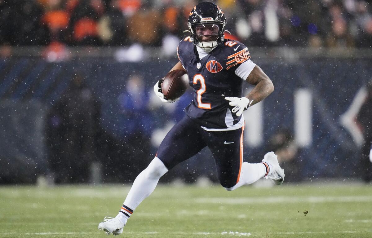 FILE - Chicago Bears wide receiver DJ Moore runs after making a catch against the Los Angeles Rams during the first half of an NFL football divisional playoff game, Jan. 18, 2026, in Chicago. (AP Photo/Jeff Roberson, File)