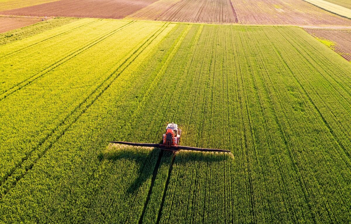 A farmer applies fertilizer to his field.