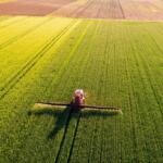 A farmer applies fertilizer to his field.