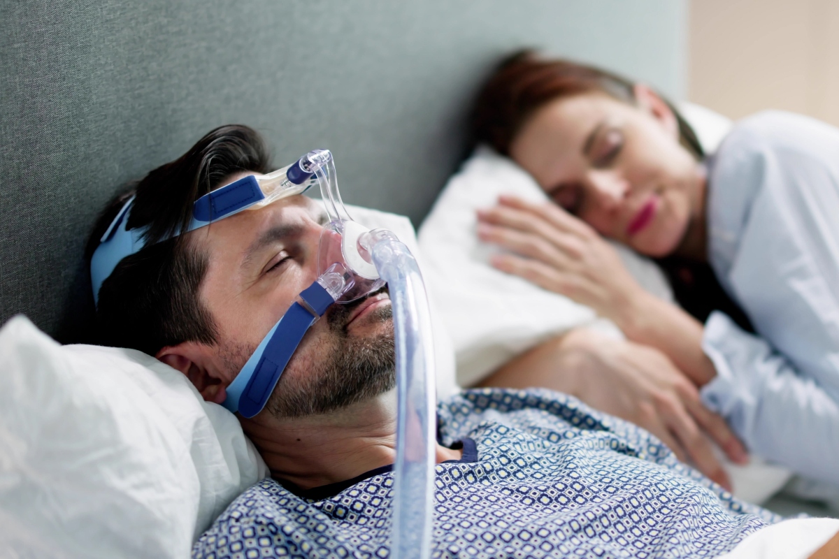 A man uses a CPAP machine to help him sleep.