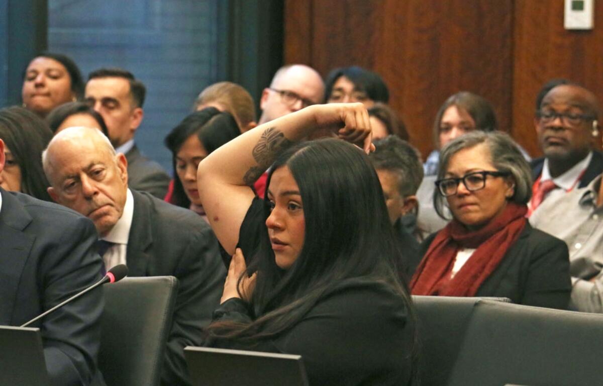 Marimar Martinez testifies at an April 28, 2026, hearing of the Illinois Accountability Commission, showing one of the seven holes left in her body after she was shot by a Border Patrol agent in October. (Capitol News Illinois photo by Maggie Dougherty)