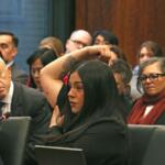 Marimar Martinez testifies at an April 28, 2026, hearing of the Illinois Accountability Commission, showing one of the seven holes left in her body after she was shot by a Border Patrol agent in October. (Capitol News Illinois photo by Maggie Dougherty)