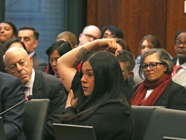 Marimar Martinez testifies at an April 28, 2026, hearing of the Illinois Accountability Commission, showing one of the seven holes left in her body after she was shot by a Border Patrol agent in October. (Capitol News Illinois photo by Maggie Dougherty)