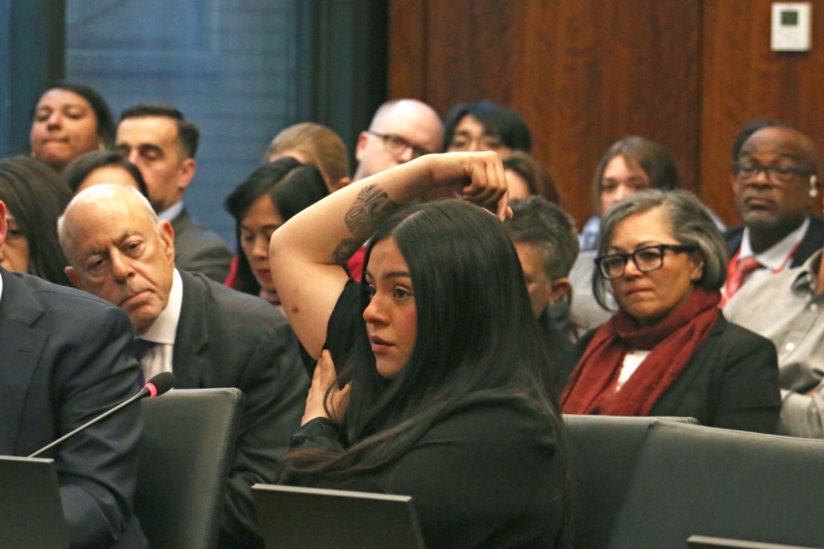 Marimar Martinez testifies at an April 28, 2026, hearing of the Illinois Accountability Commission, showing one of the seven holes left in her body after she was shot by a Border Patrol agent in October. (Capitol News Illinois photo by Maggie Dougherty)