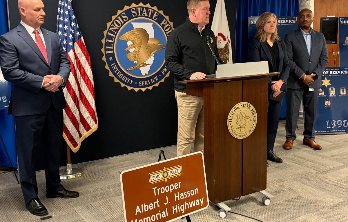 Brendan Kelly (center), Director of Illinois State Police, announces the installation of highway signs for all 73 troopers who have died in the line of duty. Trooper Albert Hassan is the first trooper, who died in 1924.