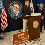 Brendan Kelly (center), Director of Illinois State Police, announces the installation of highway signs for all 73 troopers who have died in the line of duty. Trooper Albert Hassan is the first trooper, who died in 1924.