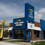 Long John Silver's storefront with a tall yellow inflatable fish outside and a 'Now Open' marquee in front.