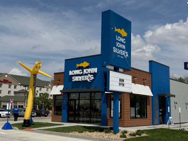 Long John Silver's storefront with a tall yellow inflatable fish outside and a 'Now Open' marquee in front.
