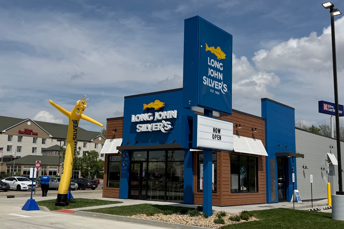 Long John Silver's storefront with a tall yellow inflatable fish outside and a 'Now Open' marquee in front.