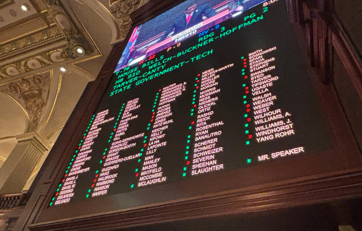 Inside an ornate hall, a large electronic scoreboard lists names in columns with green and red markers, with a TV feed above.