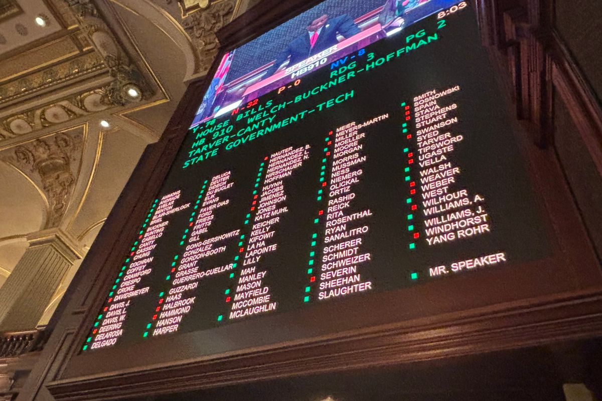 Inside an ornate hall, a large electronic scoreboard lists names in columns with green and red markers, with a TV feed above.