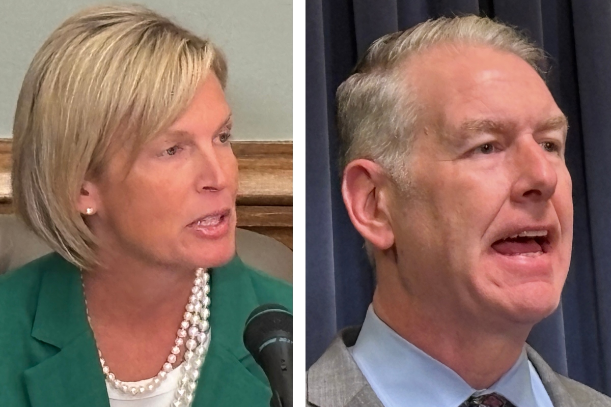 Two people in separate frames: left, a blonde woman in a green blazer with a pearl necklace speaking into a microphone; right, a gray-haired man in a suit speaking.
