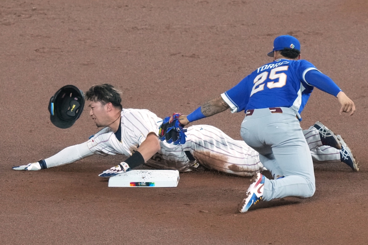 Japan's Seiya Suzuki is tagged out at second base by Venezuela's Gleyber Torres during the first inning of a World Baseball Classic quarterfinal game against Japan, Saturday, March 14, 2026, in Miami. (AP Photo/Marta Lavandier)