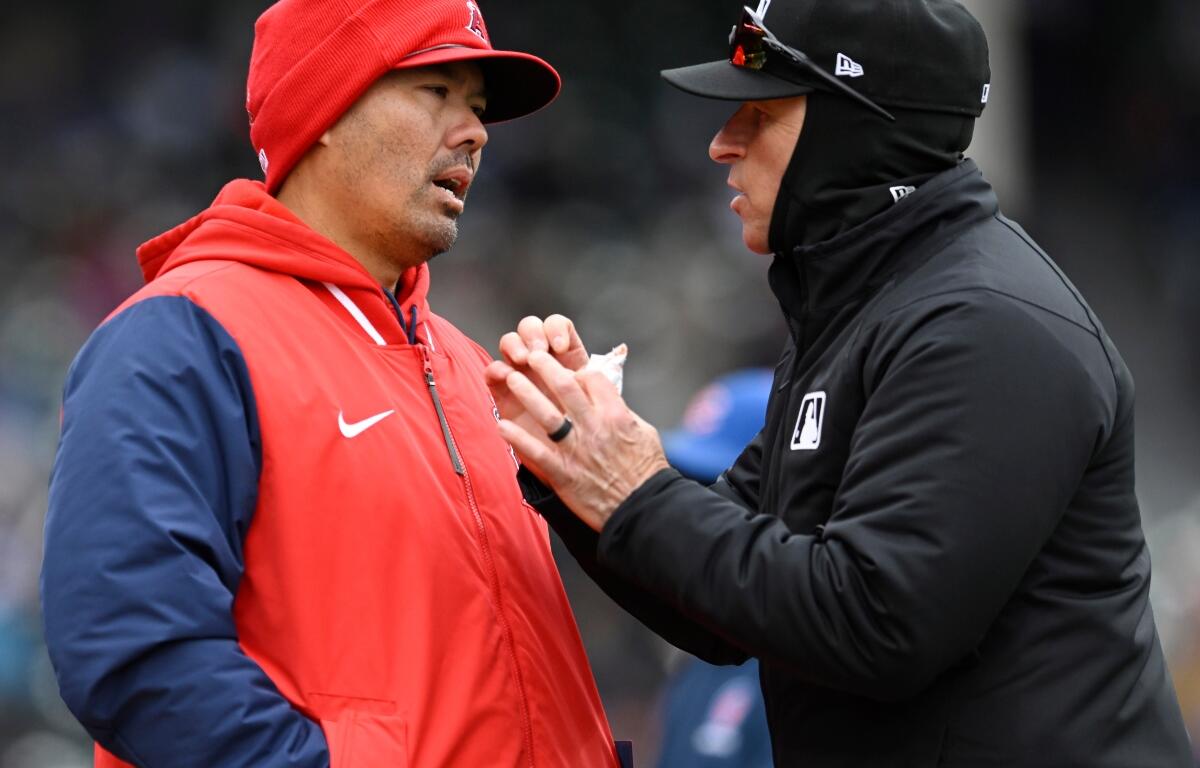Los Angeles Angels manager Kurt Suzuki, left, attempts to challenge a play with an umpire during the third inning of a baseball game against the Chicago Cubs in Chicago, Wednesday, April 1, 2026. (AP Photo/Paul Beaty)