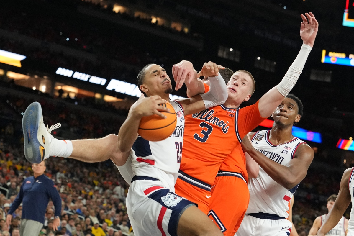 UConn's Jayden Ross (23) and Illinois' Ben Humrichous (3) battle for the ball during the first half of an NCAA college basketball tournament semifinal game at the Final Four, Saturday, April 4, 2026, in Indianapolis. (AP Photo/Michael Conroy)