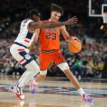 Illinois' Keaton Wagler (23) drives around UConn's Malachi Smith during the second half of an NCAA college basketball tournament semifinal game at the Final Four, Saturday, April 4, 2026, in Indianapolis. (AP Photo/Michael Conroy)