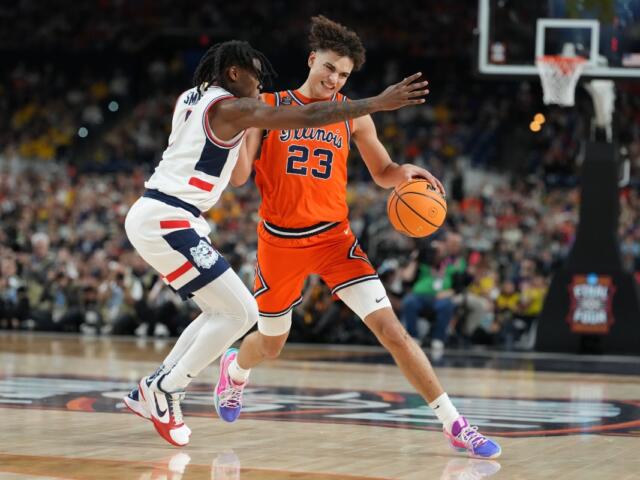 Illinois' Keaton Wagler (23) drives around UConn's Malachi Smith during the second half of an NCAA college basketball tournament semifinal game at the Final Four, Saturday, April 4, 2026, in Indianapolis. (AP Photo/Michael Conroy)