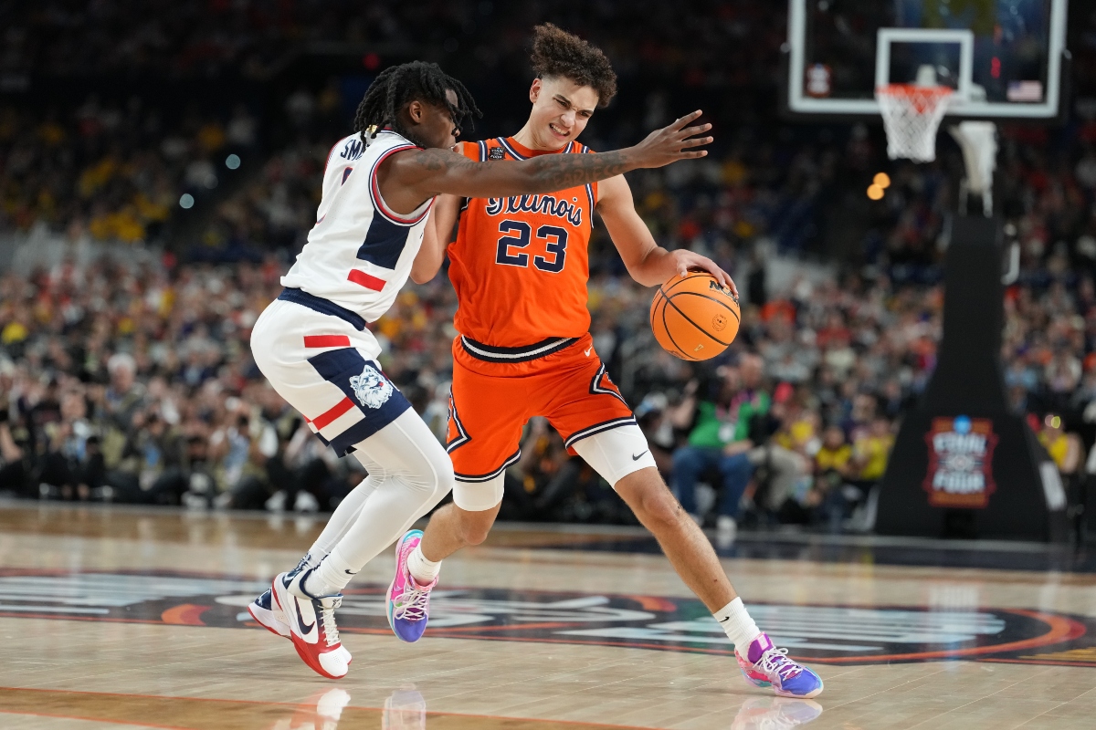 Illinois' Keaton Wagler (23) drives around UConn's Malachi Smith during the second half of an NCAA college basketball tournament semifinal game at the Final Four, Saturday, April 4, 2026, in Indianapolis. (AP Photo/Michael Conroy)