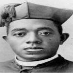 Young man in a graduation cap and gown facing the camera (black-and-white portrait).