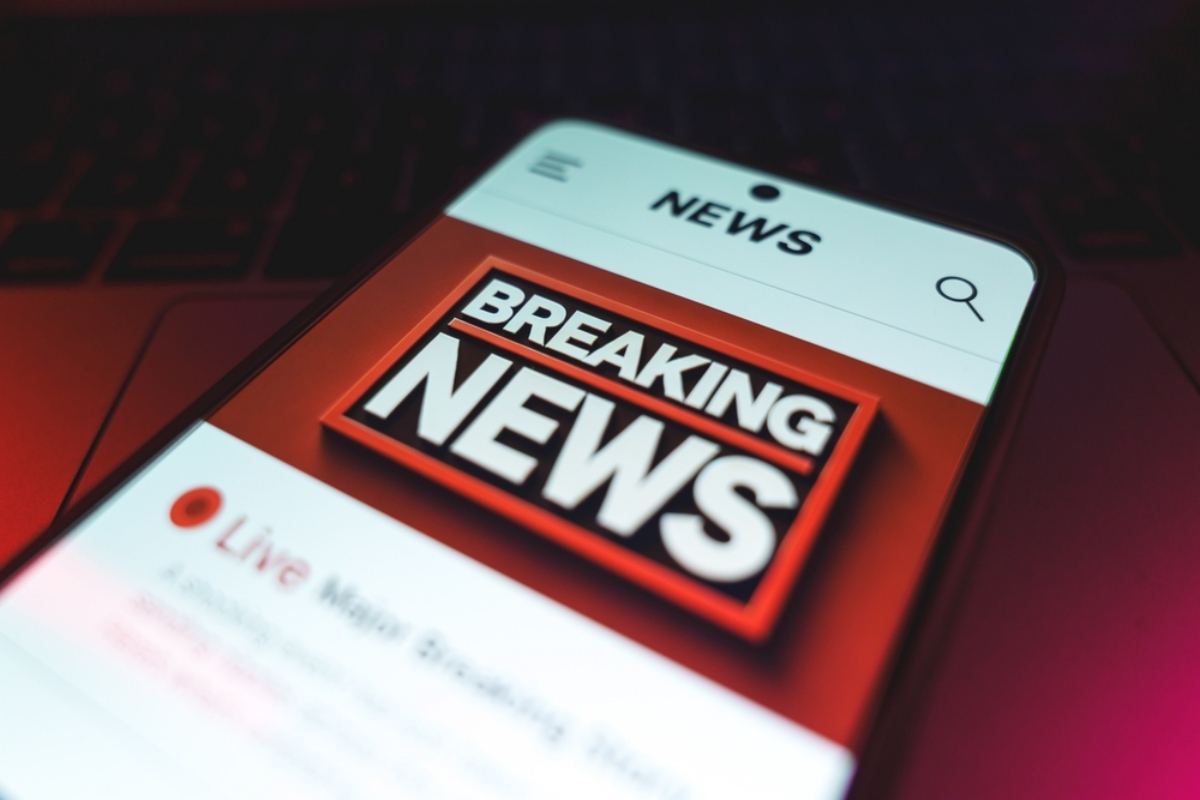 Smartphone screen showing a bold 'BREAKING NEWS' banner in a news app.