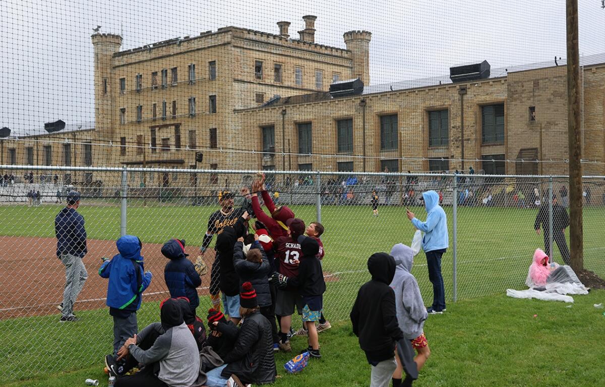 A player from the Joliet Slammers gives away a foul ball to spectators at the kickoff baseball game on April 30 at the Old Joliet Prison. (Medill Illinois News Bureau photo by Julia Levy)