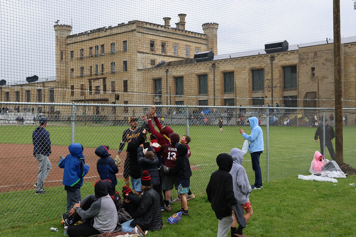 A player from the Joliet Slammers gives away a foul ball to spectators at the kickoff baseball game on April 30 at the Old Joliet Prison. (Medill Illinois News Bureau photo by Julia Levy)