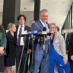Chicago’s 45th Ward Committeeman Michael Rabbitt and his wife Sarah celebrate the remaining charges being dropped against him and his co-defendants, also pictured, in the “Broadview Six” protest case. (Capitol News Illinois photo by Hannah Meisel)