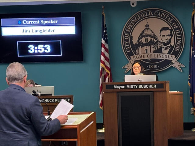 City council chamber: screen shows 'Current Speaker Jim Langfelder' at 3:53 as Mayor Misty Buscher speaks from the central podium with the Springfield, Illinois seal behind her.