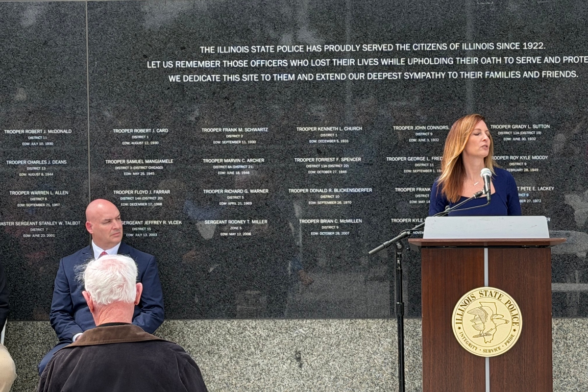 Michelle Hanneken, right, speaks at a memorial service held at the Illinois State Police Memorial Wall Wednesday, May 6, while Illinois State Police Heritage Foundation Executive Director Jarod Ingebrigtsen listens.