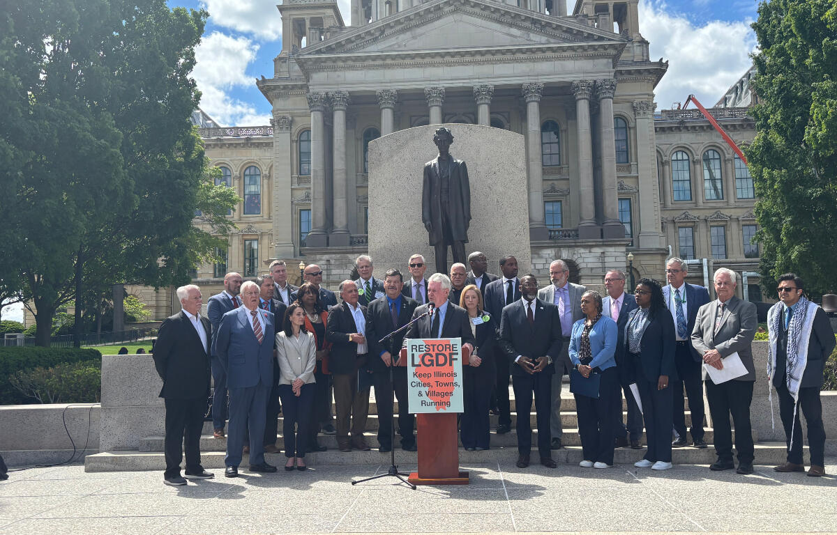 Group of officials and supporters on the steps in front of a statue at a government building, giving a press conference for Restore LGDF.