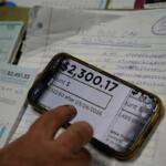 FILE - Eric Pinson, manager and resident of the Lock 24 RV Park and Campground, one of two such locations he manages in the area, looks over the business' electric bills, at his home at the campground in Racine, Ohio, March 13, 2026. (AP Photo/Carolyn Kaster, File)
