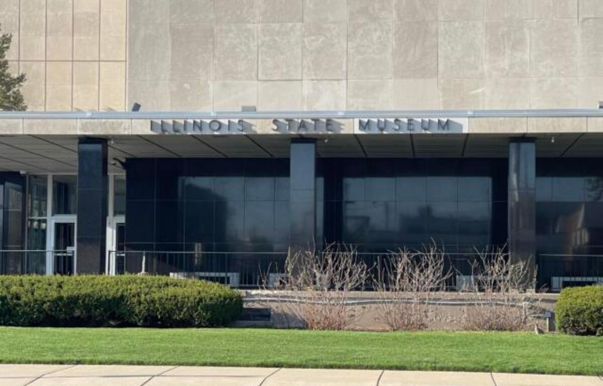Illinois State Museum building facade with glass entrance and manicured lawn in front
