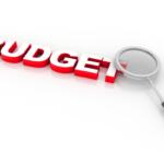 Red 3D word 'BUDGET' with a magnifying glass, implying budget review or analysis
