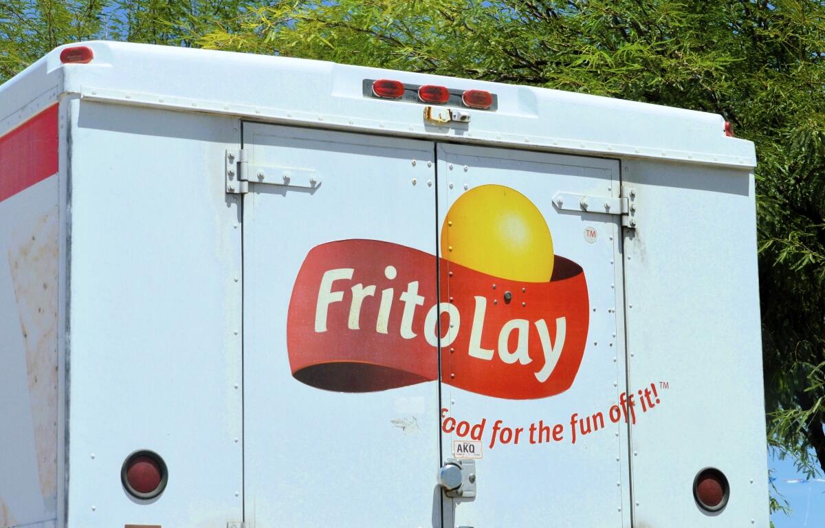 Rear of a light blue Frito-Lay delivery truck with the yellow sun logo and the slogan 'Food for the fun of it!'