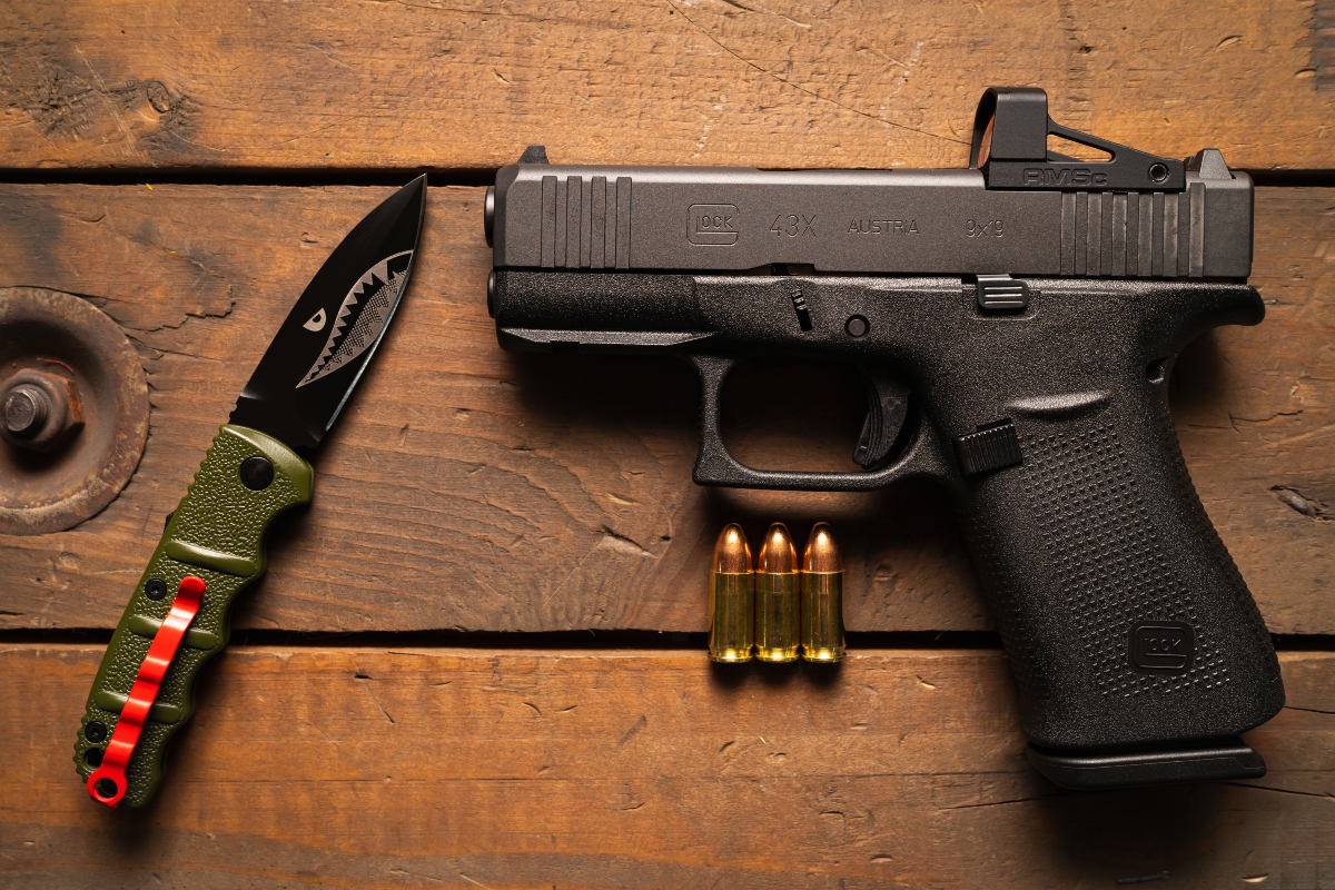 The most popular pistol for self-defense Glock 43x mos with a red dot sight and a tactical folding knife.