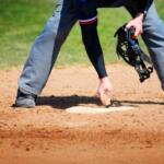 View of Baseball Umpire Brushing Off and Cleaning Home Plate with Hand Brush for Ball Game