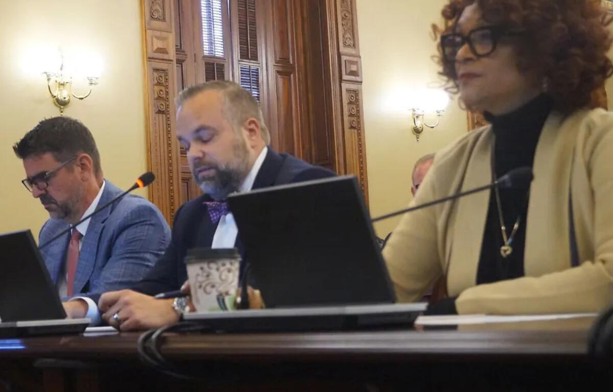 Rep. Camille Lilly, right, testifies before a House committee for passage of a bill calling for an audit of the federal 340B drug pricing program in Illinois. Also testifying were Peter Fotos, left, of Pharmaceutical Research and Manufacturers of America, and John Conrad of the Illinois Biotechnology Industry Organization. (Capitol News Illinois photo by Peter Hancock)