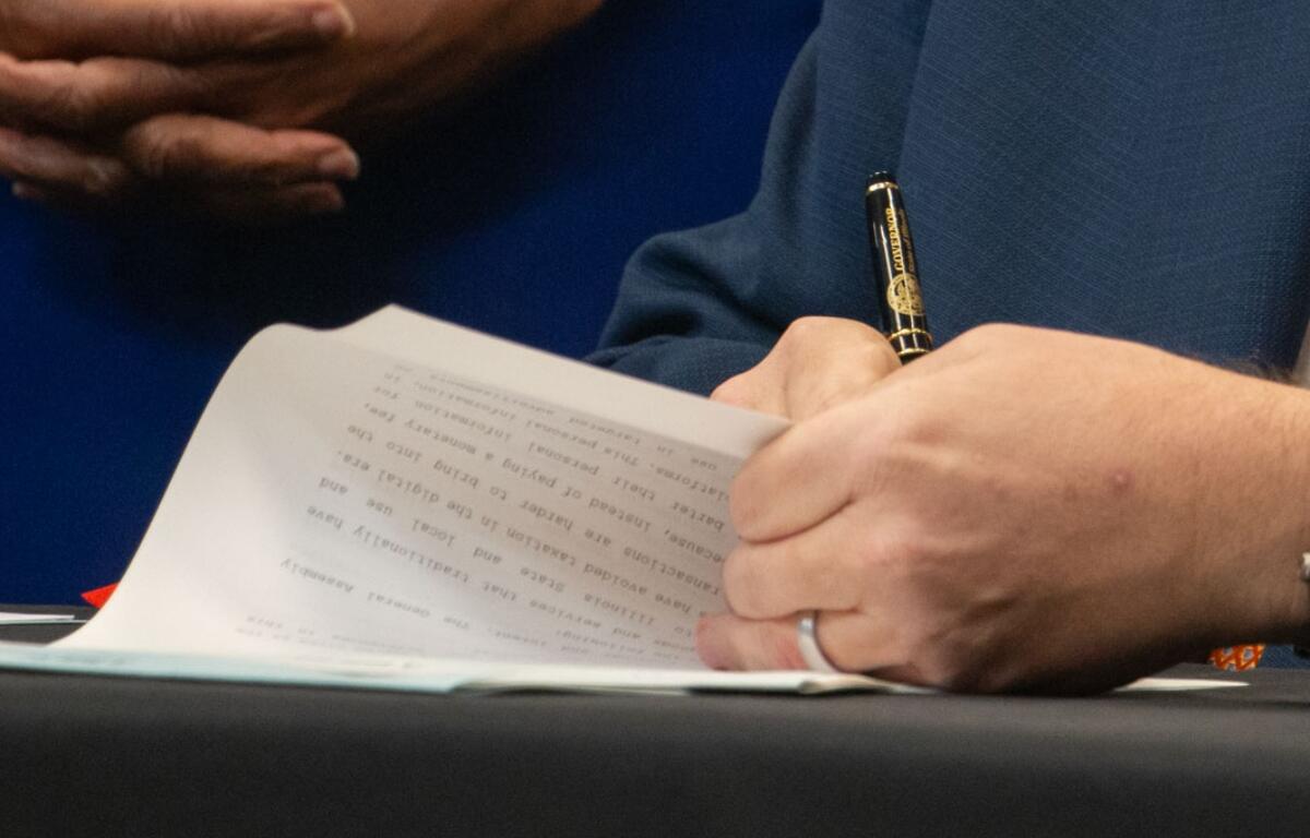 Gov. JB Pritzker signs a bill into law. (Capitol News Illinois photo by Maggie Dougherty)